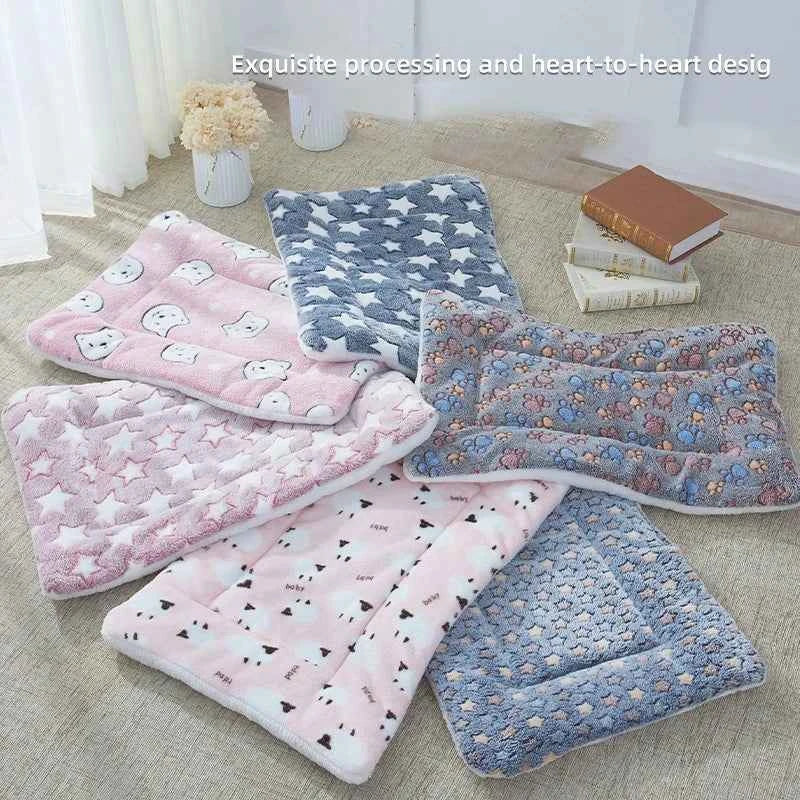 Flannel pet sleeping mat set, pink and blue patterned plush rolls folded on a couch