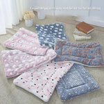 Flannel pet sleeping mat set, pink and blue patterned plush rolls folded on a couch