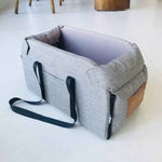Gray pet car seat bed with black side handles, open top, and padded liner