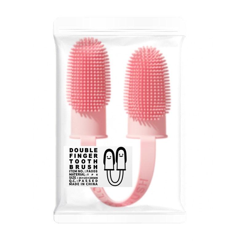 Pink silicone double finger toothbrush in sealed retail bag