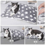 Flannel pet sleeping mat, grey with large white stars, cat lying on top