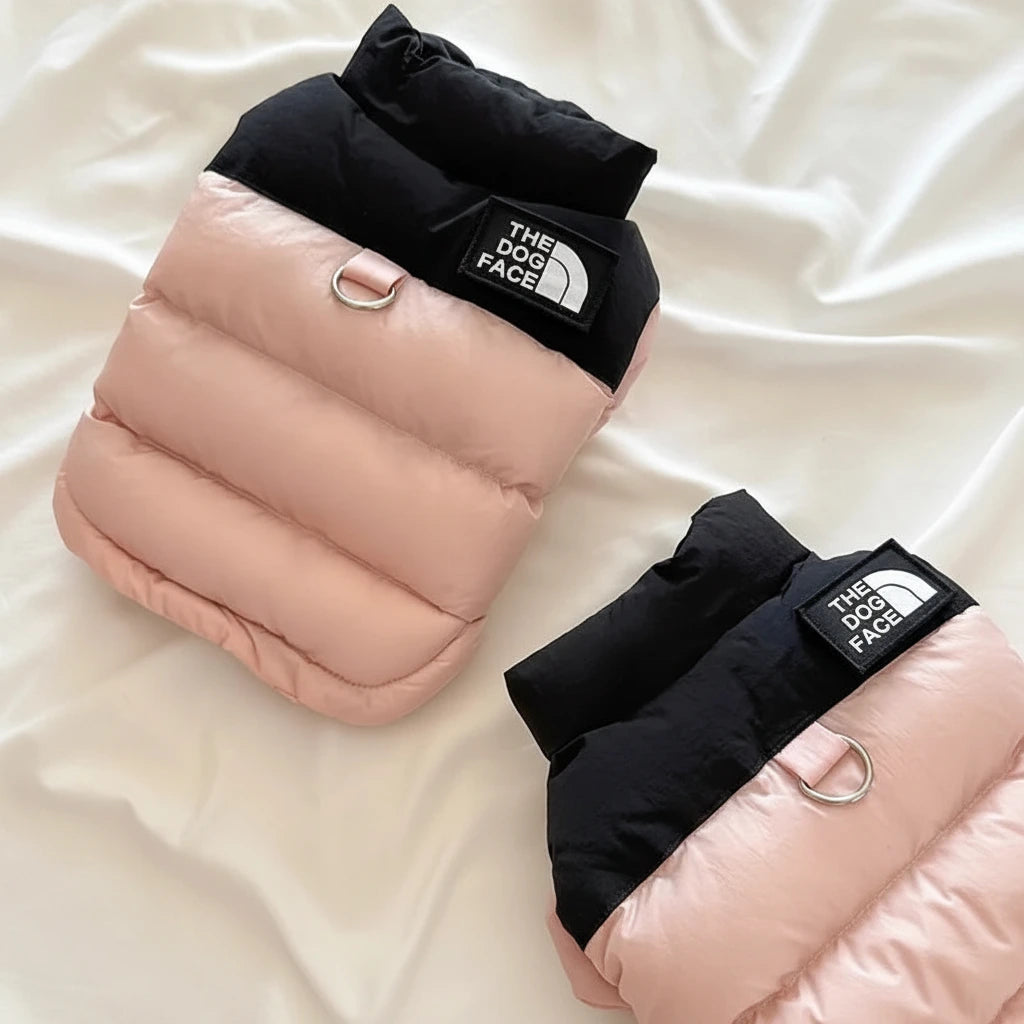 Folded pet jackets in black and blush pink with THE DOG FACE patch and leash rings