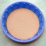 Tan round pet mat inside blue plastic tub, quilted hex surface