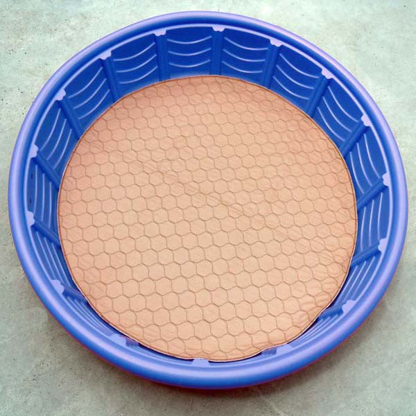 Tan round pet mat inside blue plastic tub, quilted hex surface