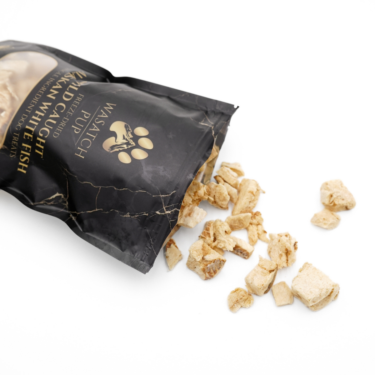Black freeze-dried fish treat pouch tipped with scattered dried fish pieces