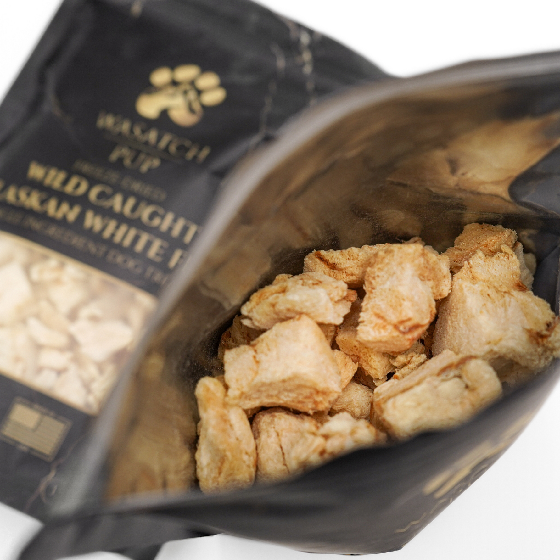 Freeze-dried fish chunks in an open pouch, close-up of dried pieces