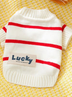 White knitted pet sweater with red horizontal stripes and blue patch text