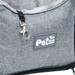 Grey pet car seat close-up with logo patch, zipper, and metal clip on strap