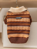 Brown knitted pet sweater with orange and white striped pattern and logo patch