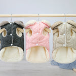 Set of quilted dog coats on hangers: black, pink, and beige with plush lining