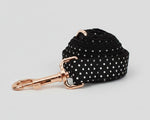 Black polka-dot leash strap with rose-gold clip and swivel; coiled for display