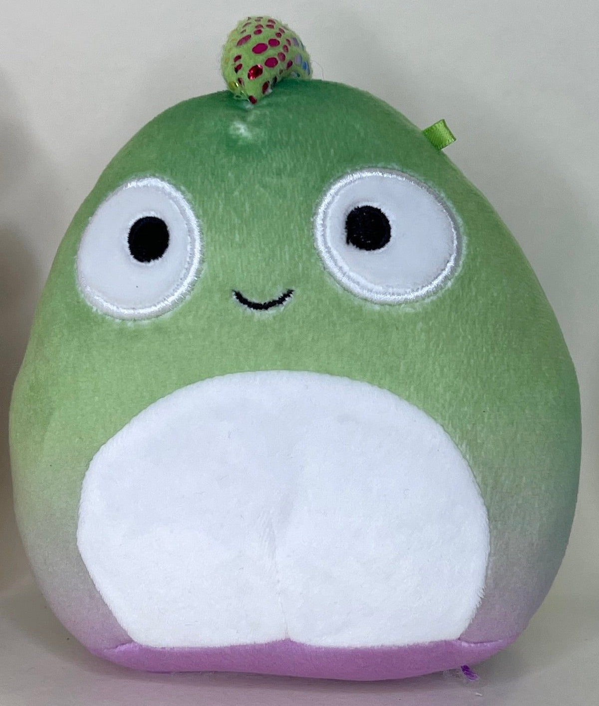 Green frog plush pet toy with big eyes, white belly, and berry on head