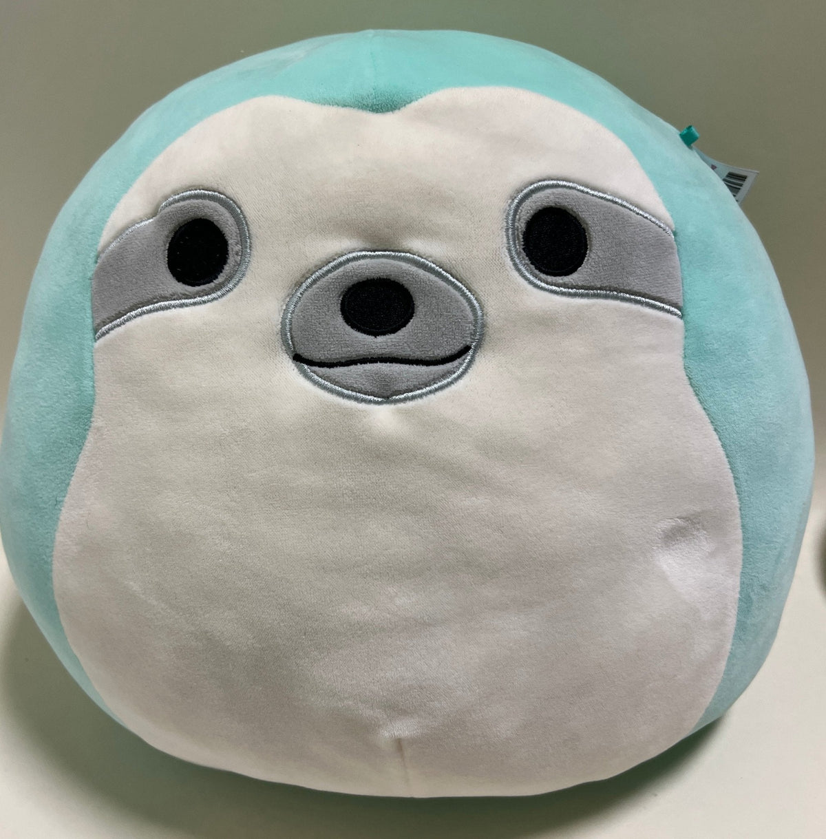 Turquoise-and-white plush seal with round black eyes and gray snout