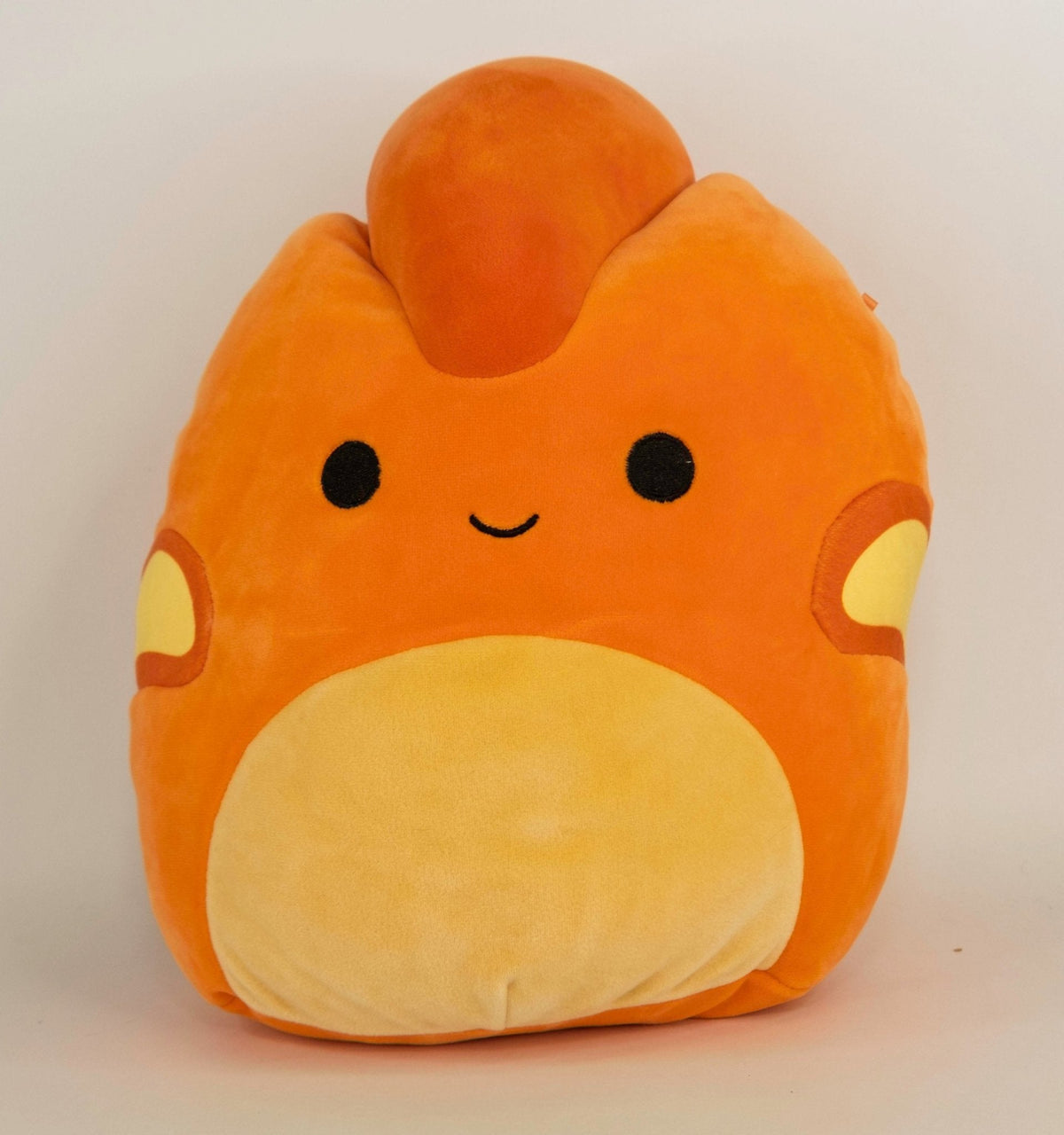 Large orange plush pet toy with heart-shaped muzzle, black eyes, and squishy body