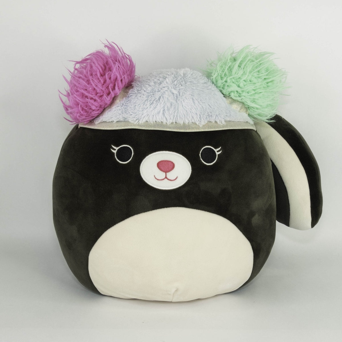Large black and white plush pet toy with pink and green yarn pom-poms, squishy