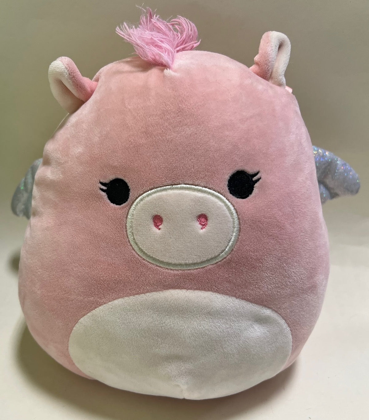 Pink pig-nose plush squishy pet toy with stitched eyes and small horn-like tuft