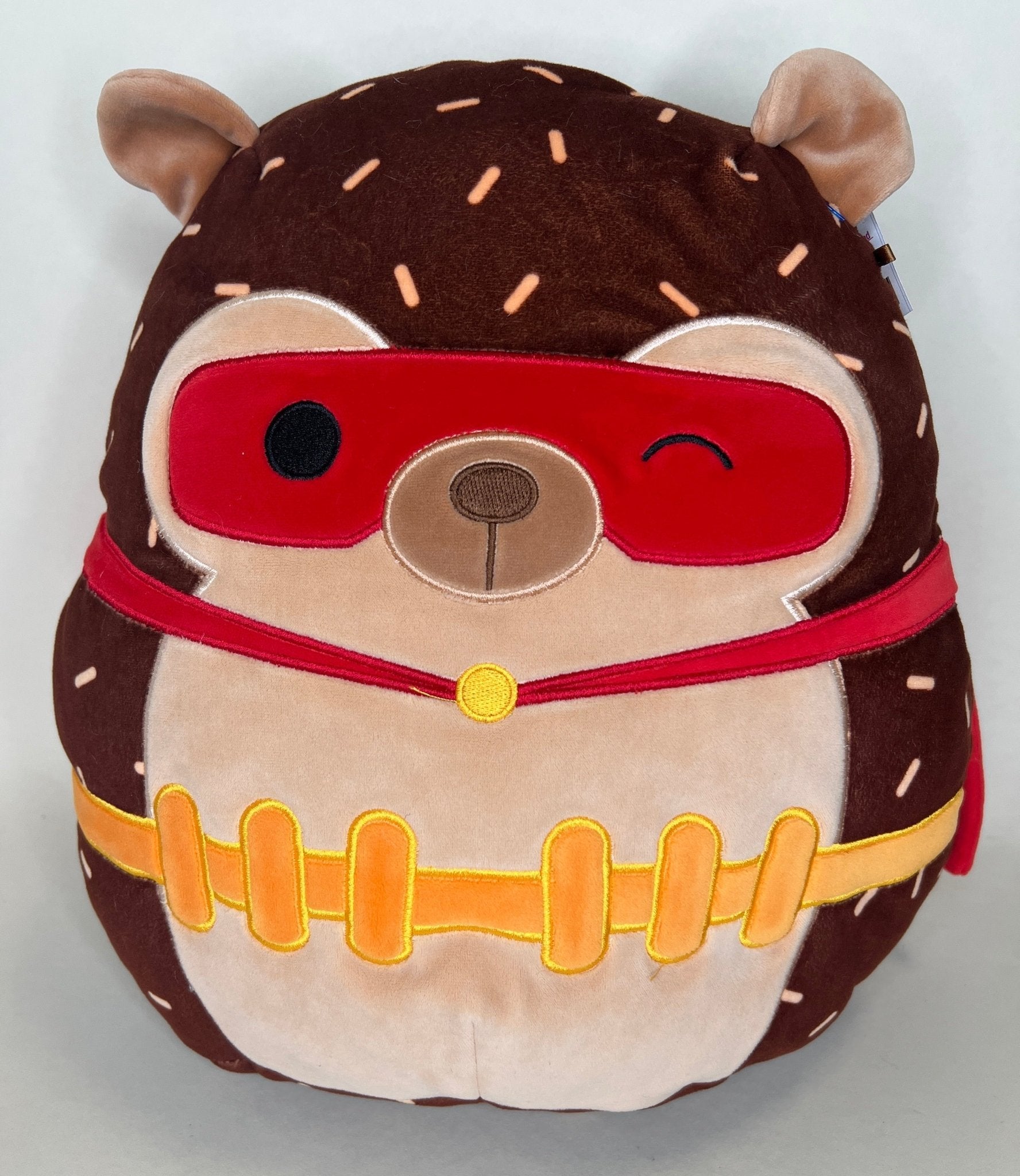 Brown plush animal with red swim-goggles and colorful striped belly detail