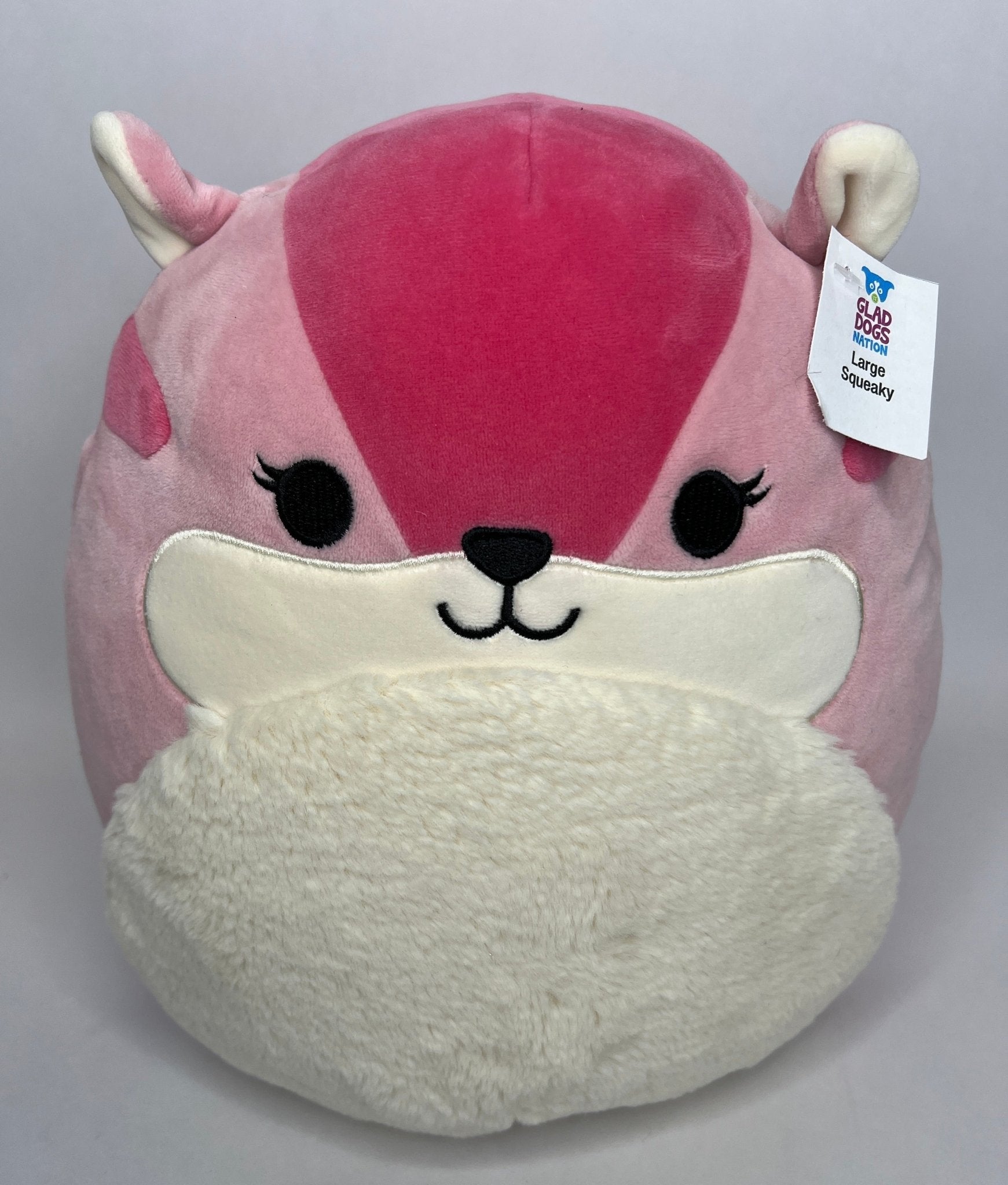 Large pink plush animal with horn, cream muzzle, and fuzzy white belly