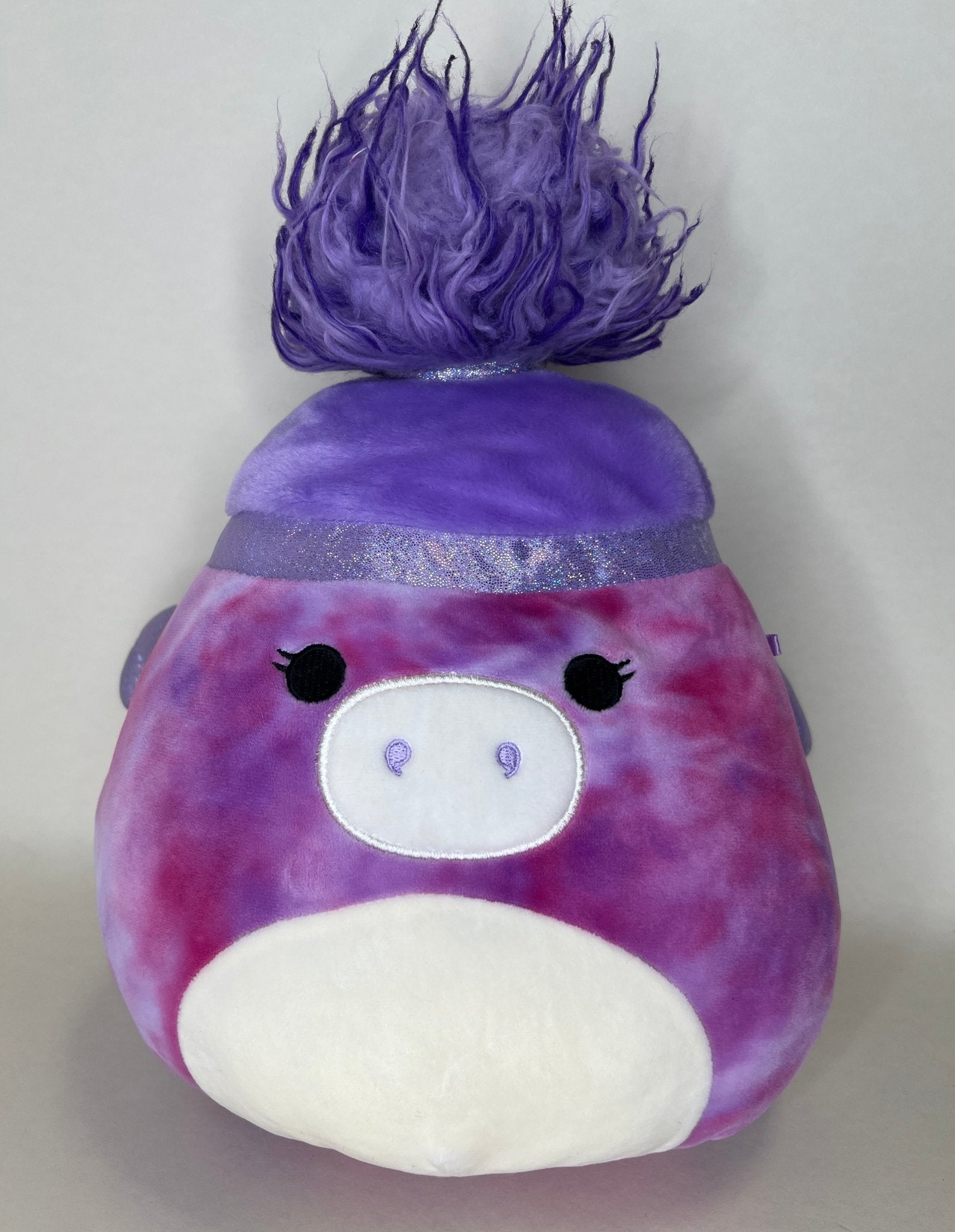 Purple plush creature with spiky hair, small eyes, and white belly