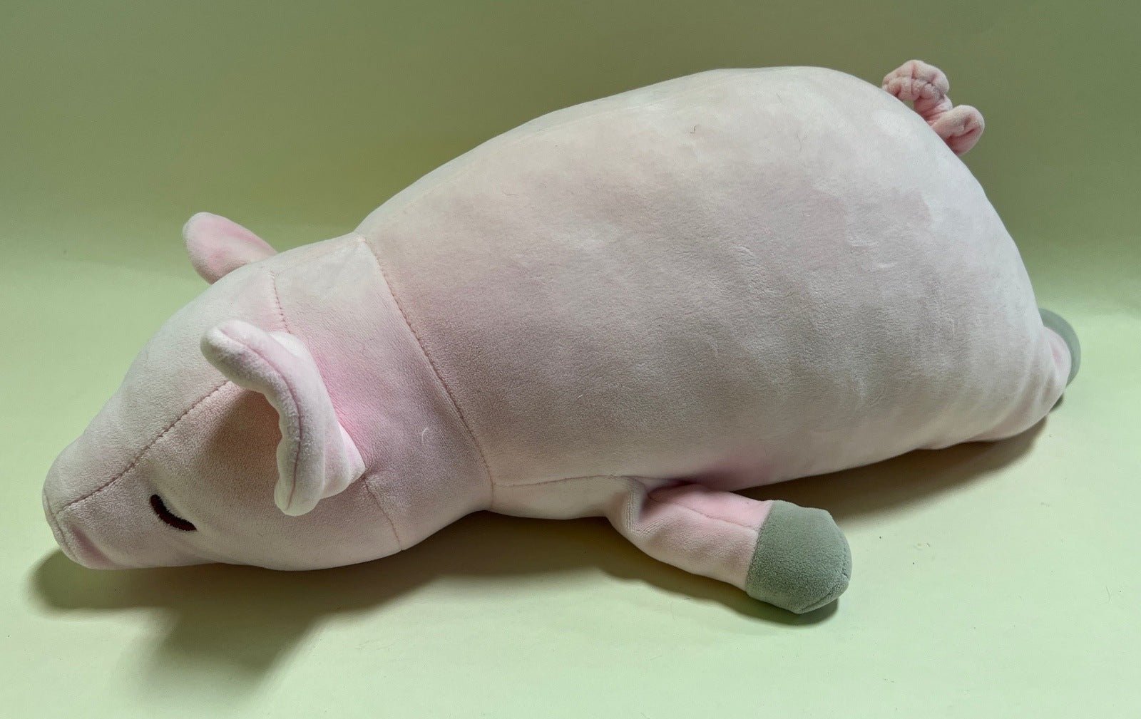 Sleeping pastel plush squishy pet toy with curled body and small pink paw details