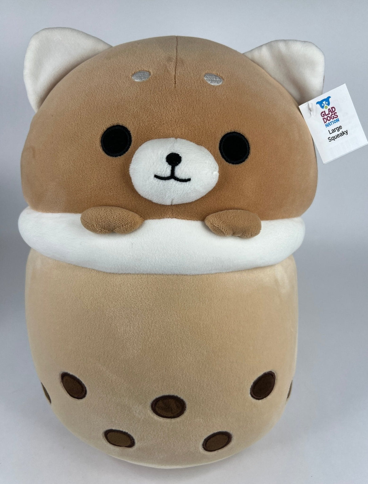 Large squishy plush pet toy, tan and cream cat-like head with paws and patterned body