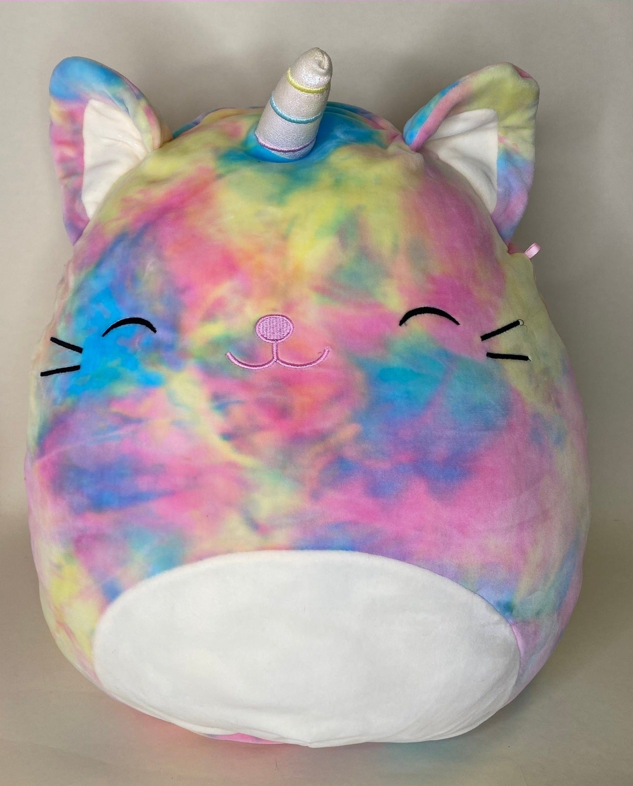 Rainbow tie-dye unicorn cat plush pet toy with horn and closed-eye face