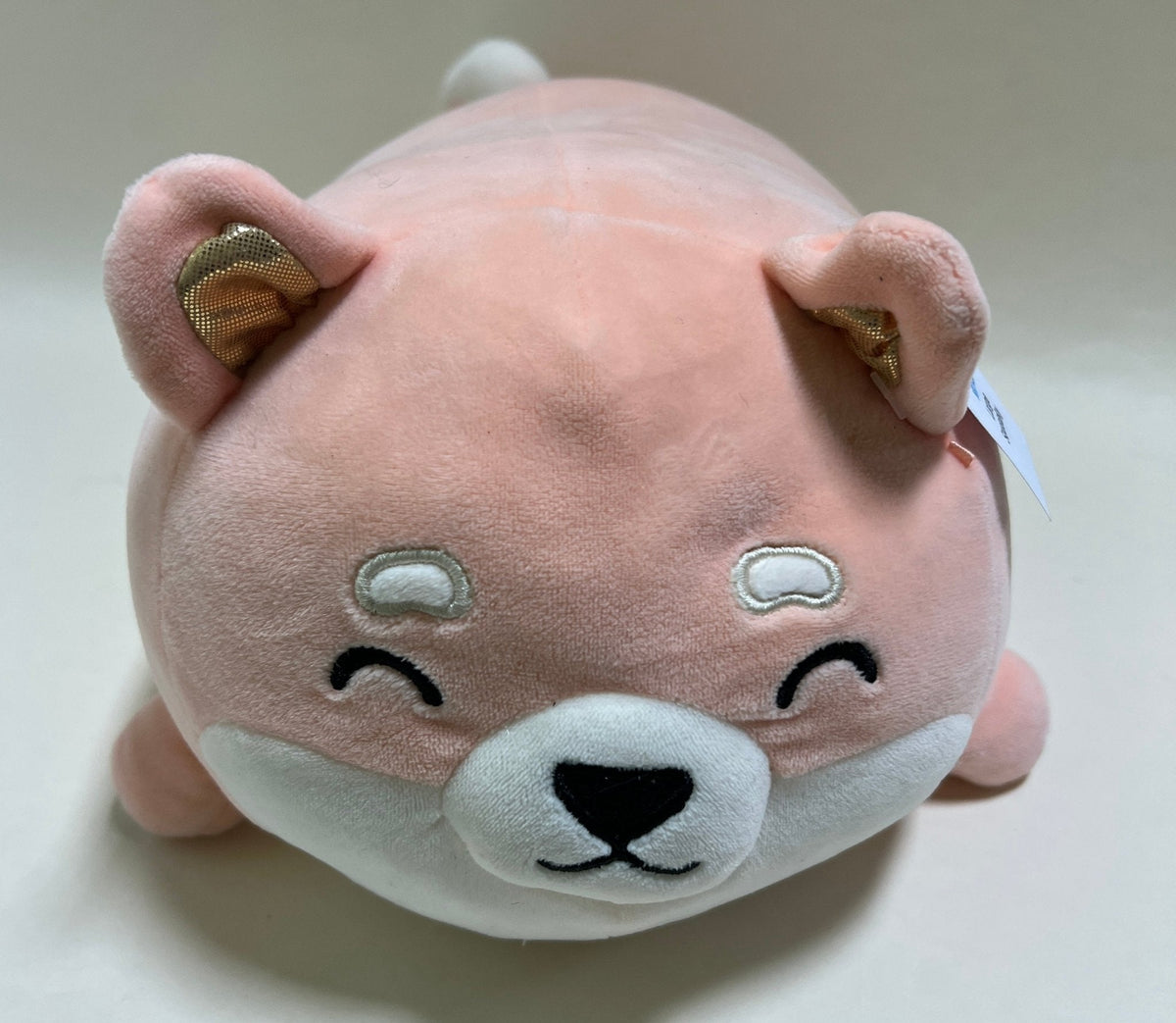 Large tan-brown squishy plush pet toy with cloud patches, closed eyes, and black nose