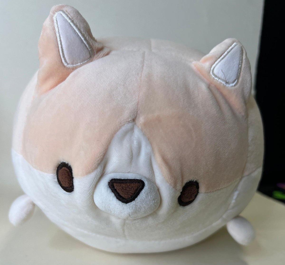 Cream plush pet toy with brown accents, sleepy eyes, and pointy ear details