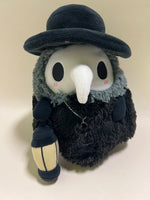 Black plush bird with tall hat, red-lined eyes, and small hanging charm