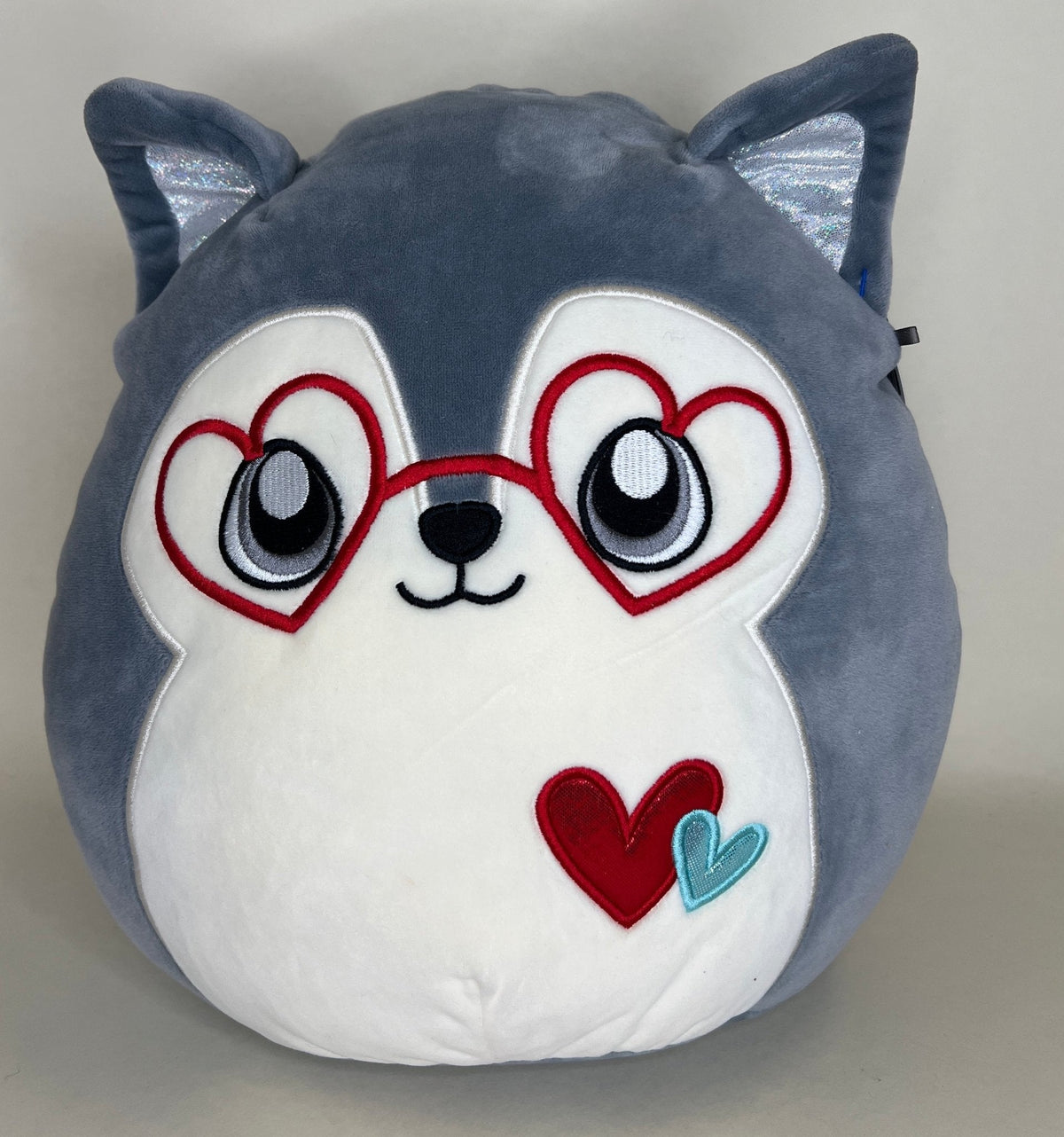Blue-gray plush cat with heart-shaped red glasses and heart on the chest