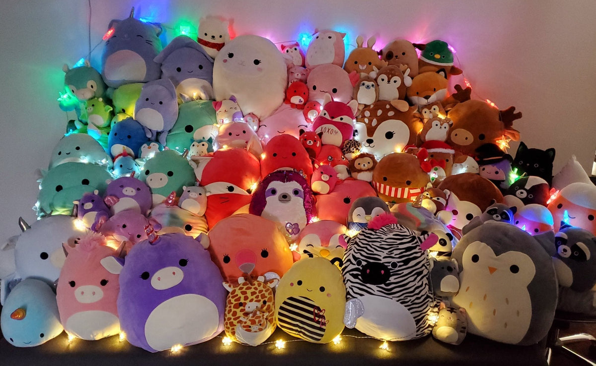 Assorted plush squishy animal toys with glowing LED lights in a packed row