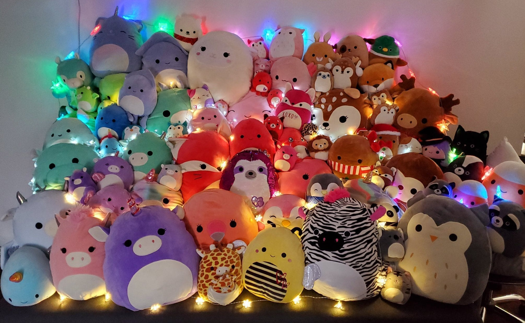 Assorted plush squishy animal toys with glowing LED lights in a packed row