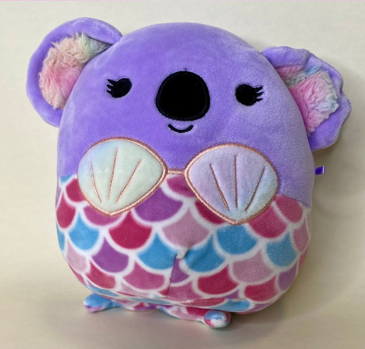 Purple plush mermaid-style pet toy with scallop shell pattern and cute face