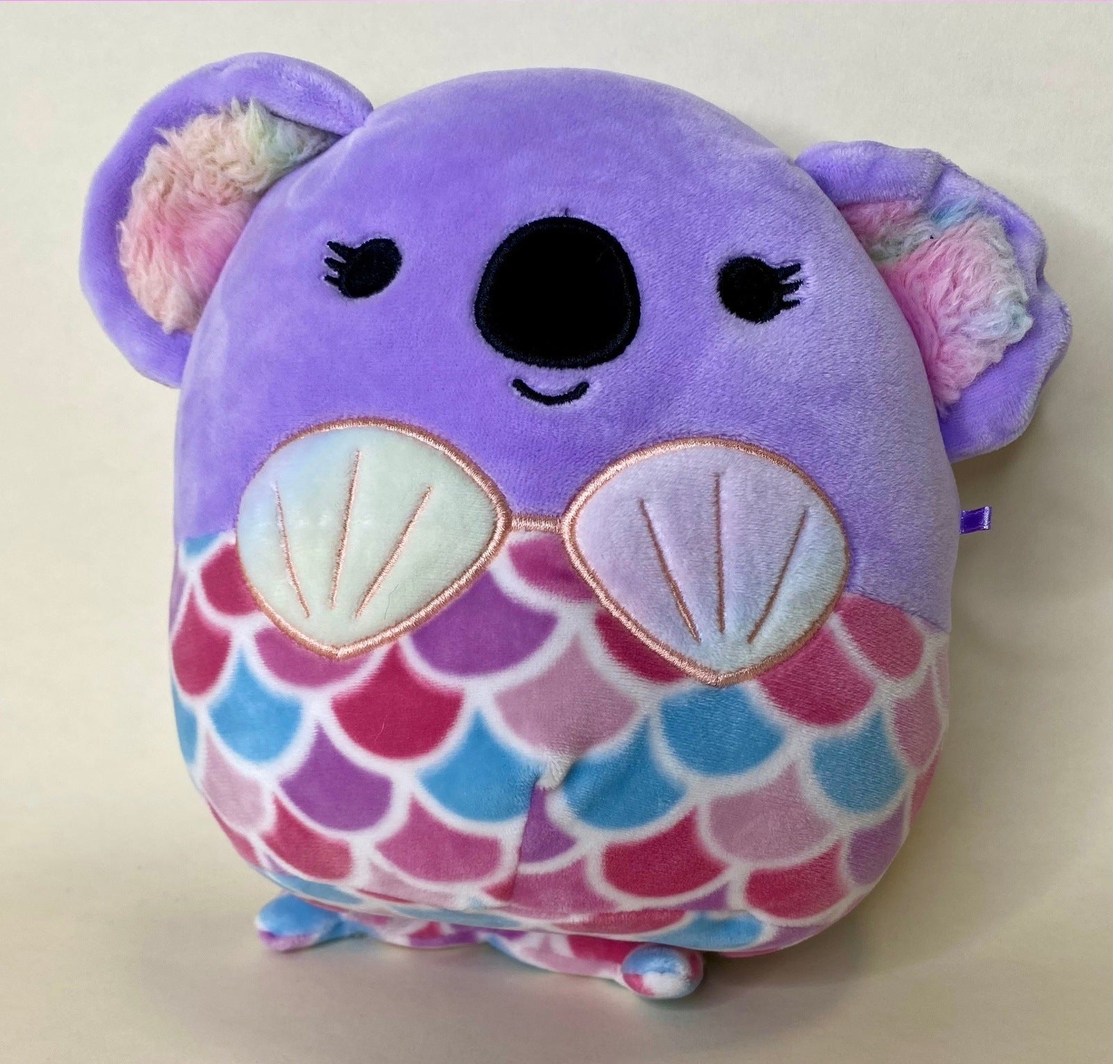 Purple plush mermaid-style pet toy with scallop shell pattern and cute face