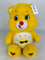 Yellow plush dog toy bear with sunshine badge and sunglasses smile on belly.