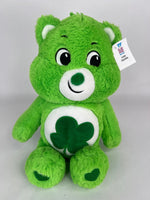 Green plush dog toy bear with clover belly applique and friendly stitched smile.