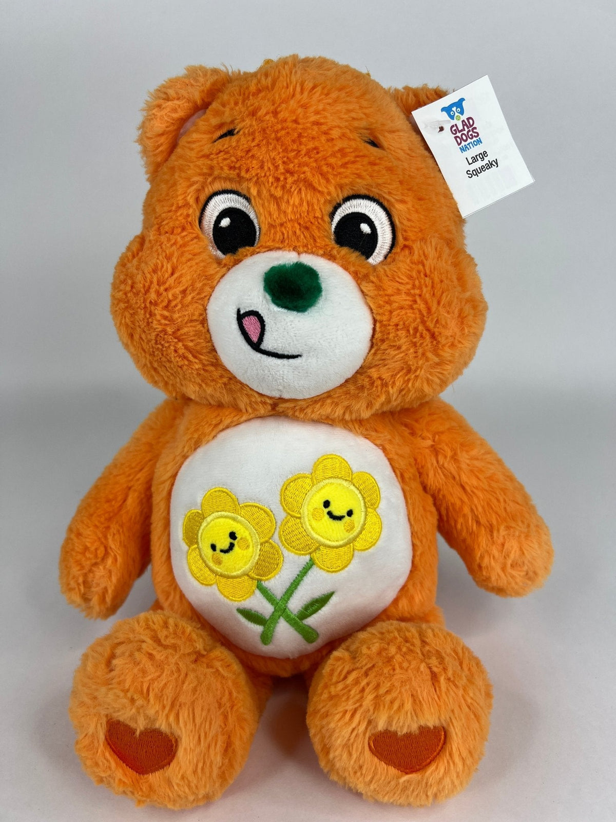 Upcycled plush dog toy, orange bear with white belly flower patch and heart paw details, tag