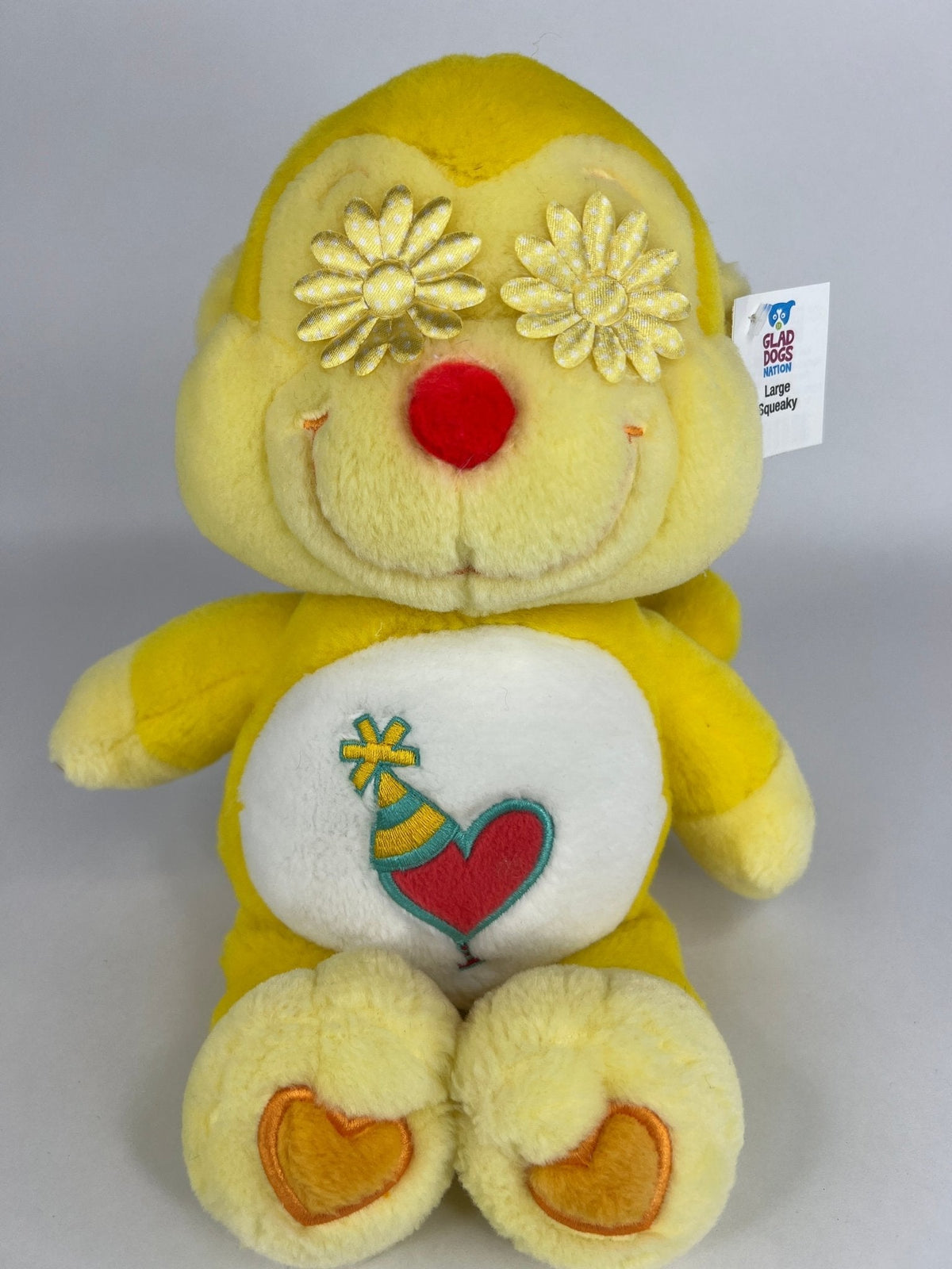 Upcycled plush dog toy, yellow bear with flower head top and heart belly patch, brand tag