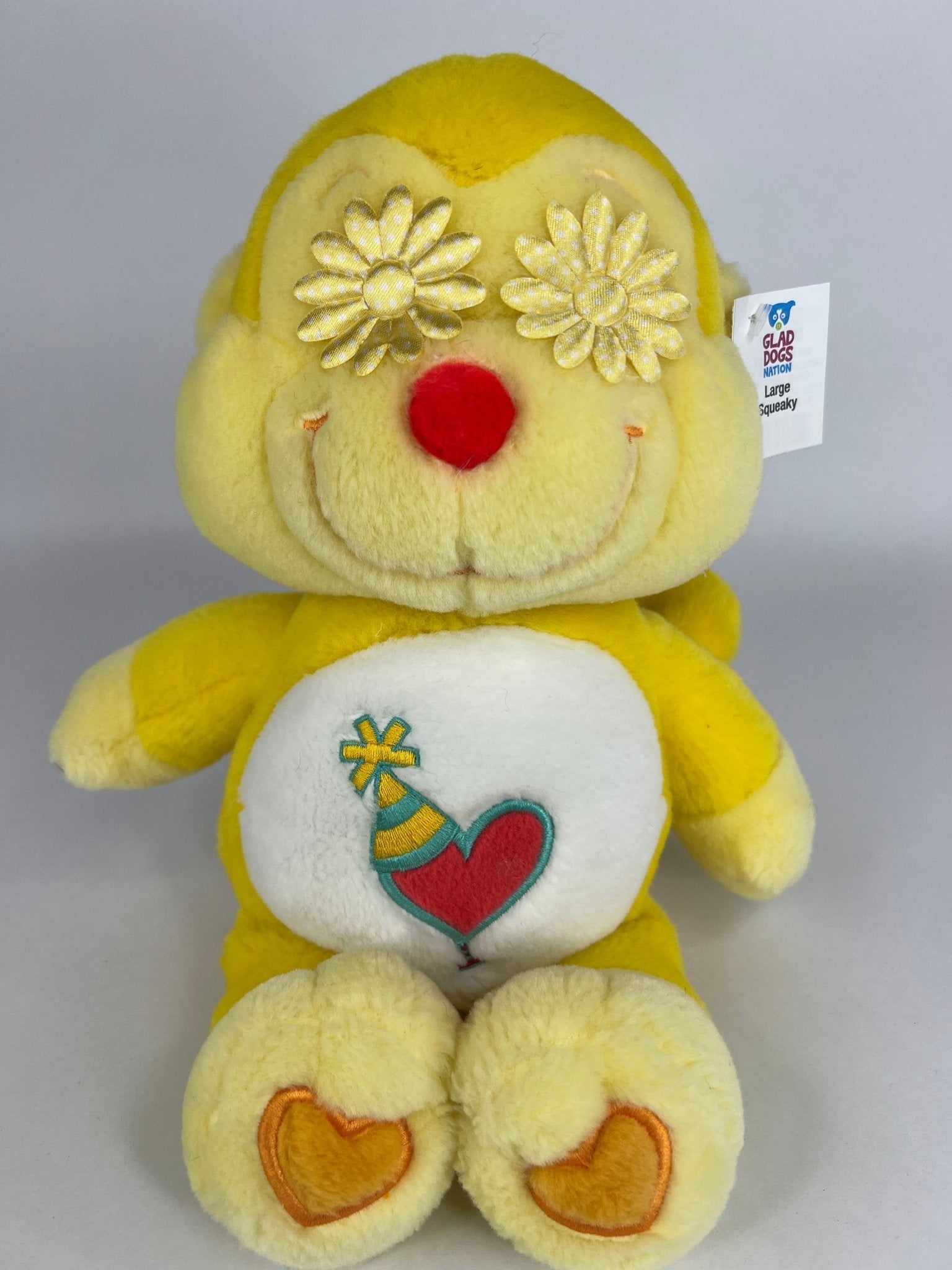 Upcycled plush dog toy, yellow bear with flower head top and heart belly patch, brand tag