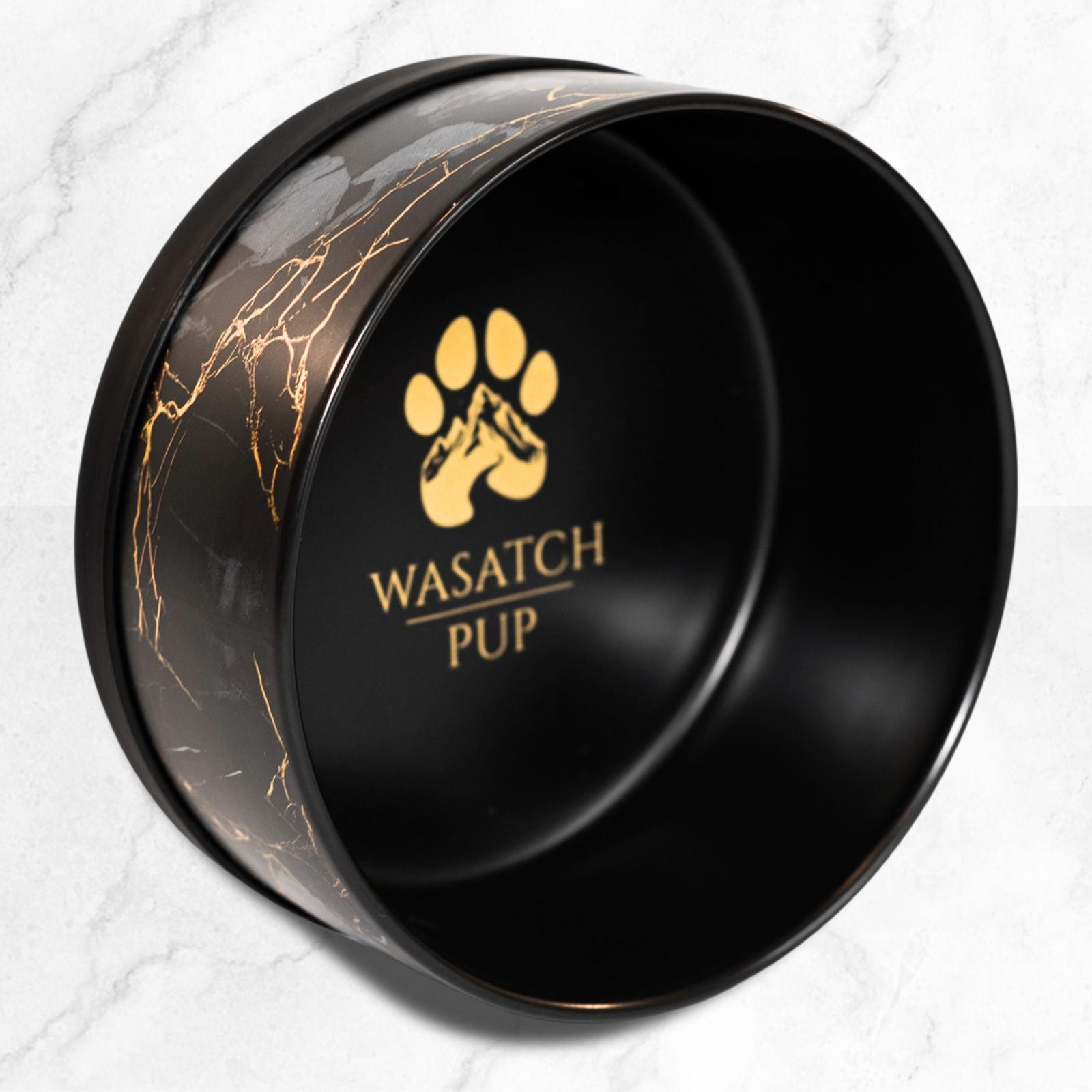Black ceramic pet bowl with gold marble pattern and Wasatch Pup logo on interior