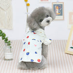 Cream pet shirt with red/blue mushroom print, short sleeves, worn by gray dog