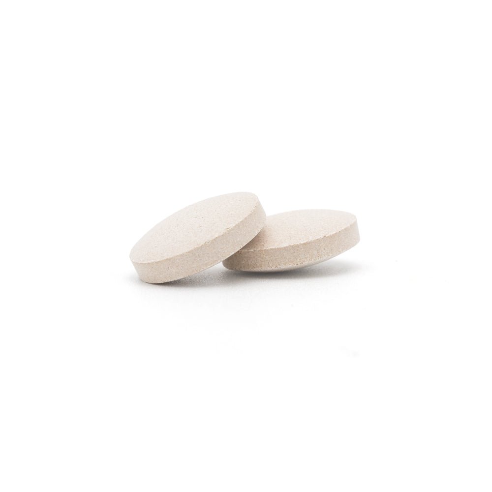 Two light beige round dog detox tablets