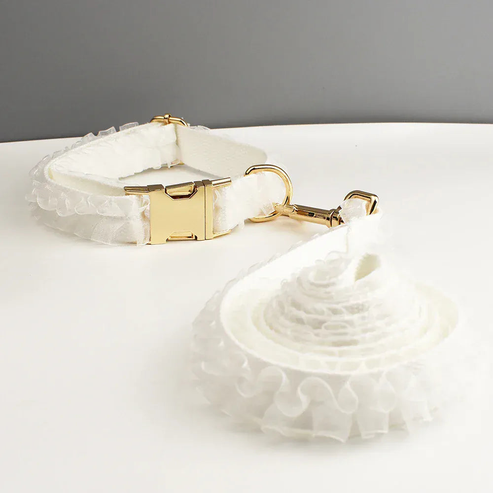 White ruffled dog collar with gold-tone buckle and leash attachment clip