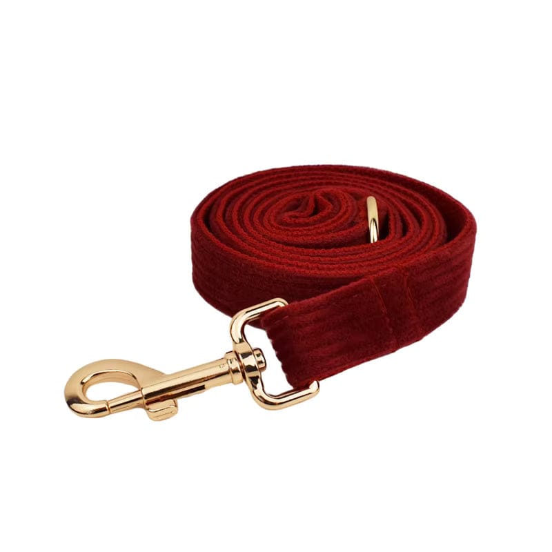 Dark red corduroy dog leash rolled up with gold-tone clasp and hook