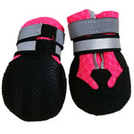 Pair of red dog shoe covers with black rubber soles and hook-and-loop strap