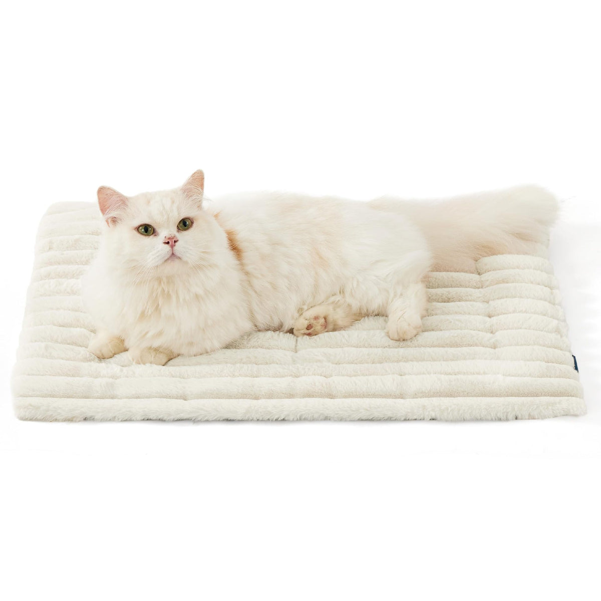 White faux rabbit fur pet mat with quilted ribbed surface, with a cream cat resting.