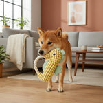 Yellow seahorse plush dog toy with rope handle, held in a dog’s mouth