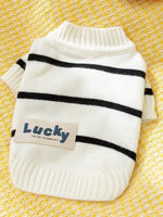 White knitted pet sweater with black horizontal stripes and blue patch text