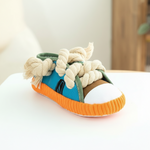 Squeaky plush shoe dog toy with teal upper, orange sole, and white rope laces