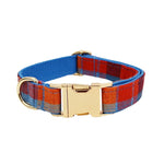 Plaid dog collar with gold-tone clasp and red-blue-orange check pattern, close-up